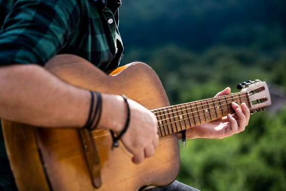 This image has an empty alt attribute; its file name is bigstock-Male-Musician-Playing-Guitar-374883052.jpg